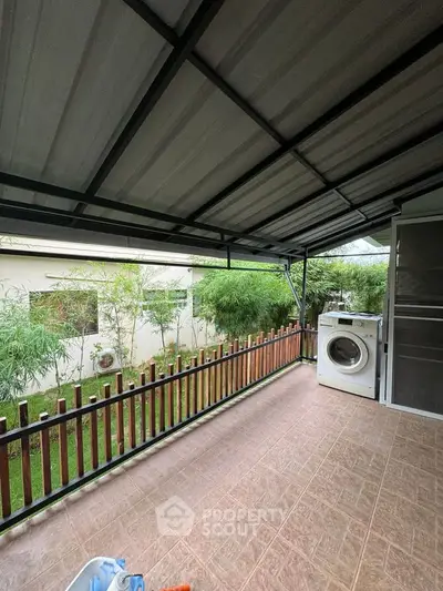 Spacious balcony with garden view and washing machine setup