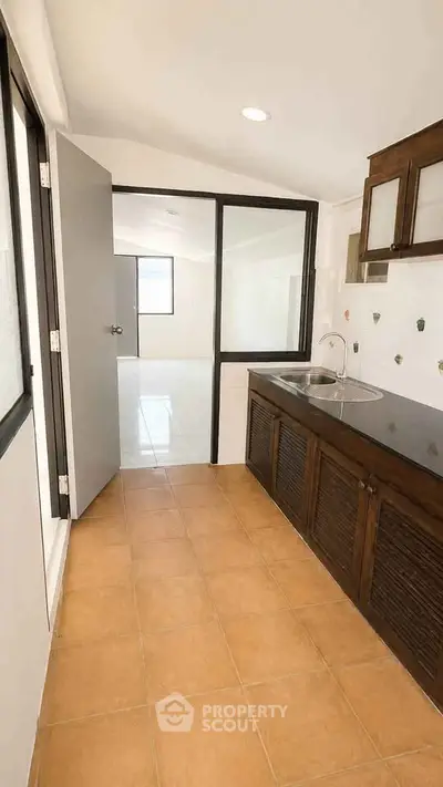 Spacious kitchen with sleek countertops and ample natural light, perfect for culinary enthusiasts.