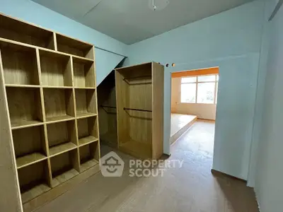 Spacious walk-in closet with wooden shelving and open layout