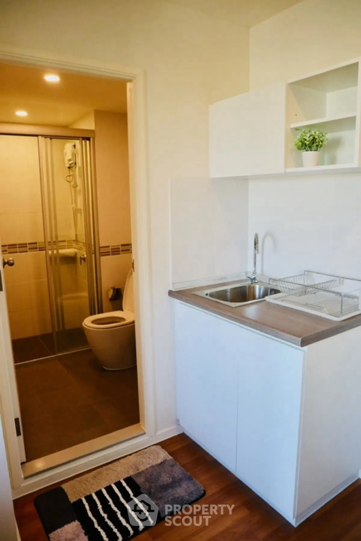 Compact studio apartment with kitchenette and bathroom, ideal for urban living.