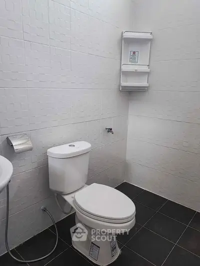 Modern bathroom with sleek white tiles and contemporary fixtures.