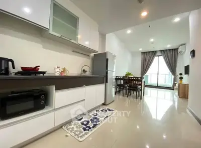 Modern open-layout kitchen and dining area with sleek appliances and bright natural lighting.