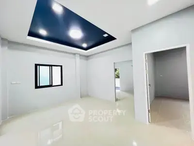 Modern minimalist living room with sleek ceiling design and neutral tones.