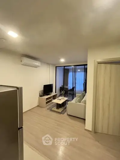 Modern living room with sleek design and air conditioning, featuring a cozy seating area and TV setup.