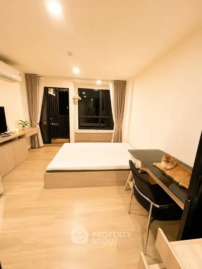 Modern bedroom with wooden flooring, cozy bed, and stylish desk, perfect for urban living.
