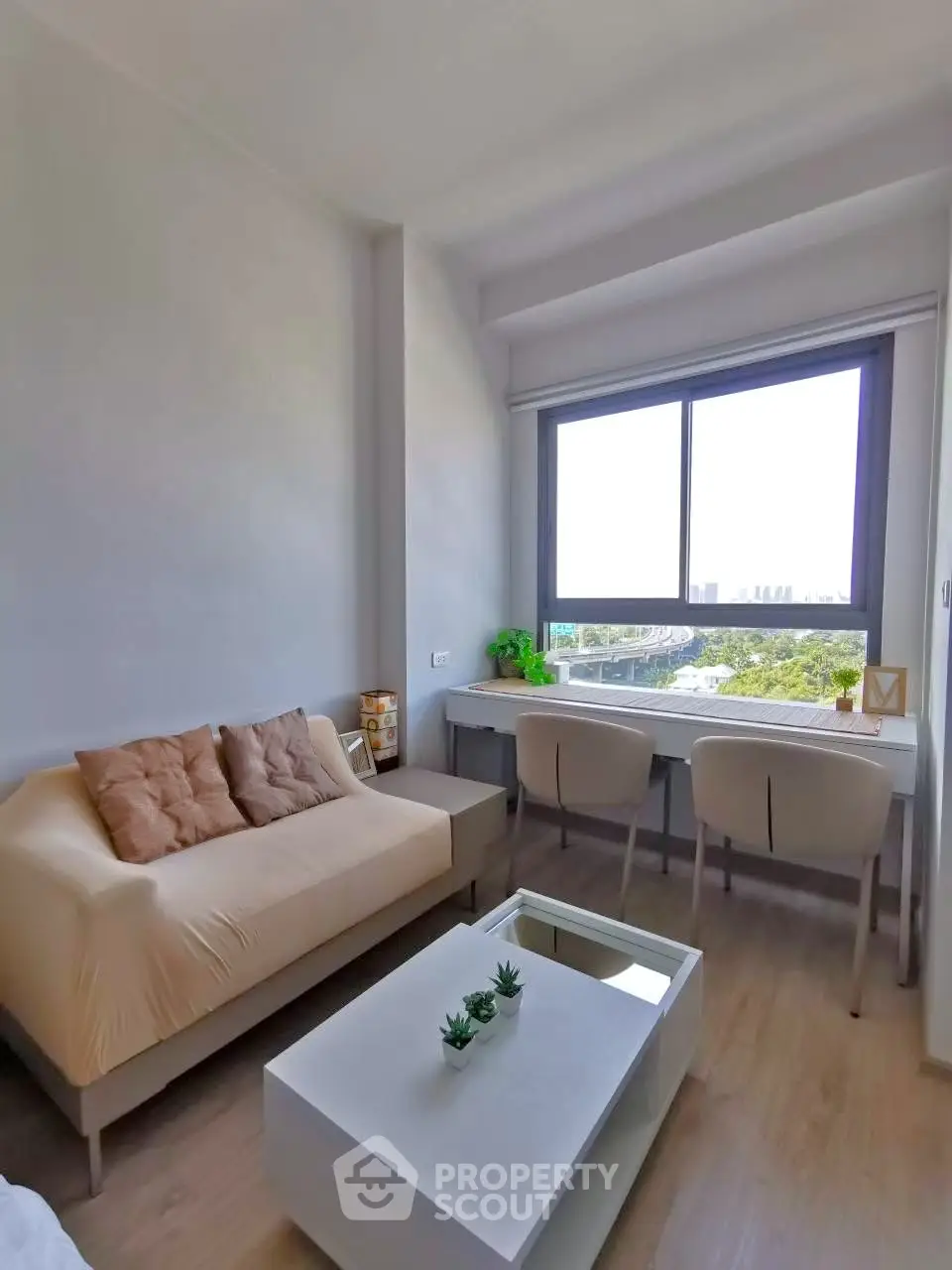 Modern living room with cozy sofa and large window offering a stunning city view.