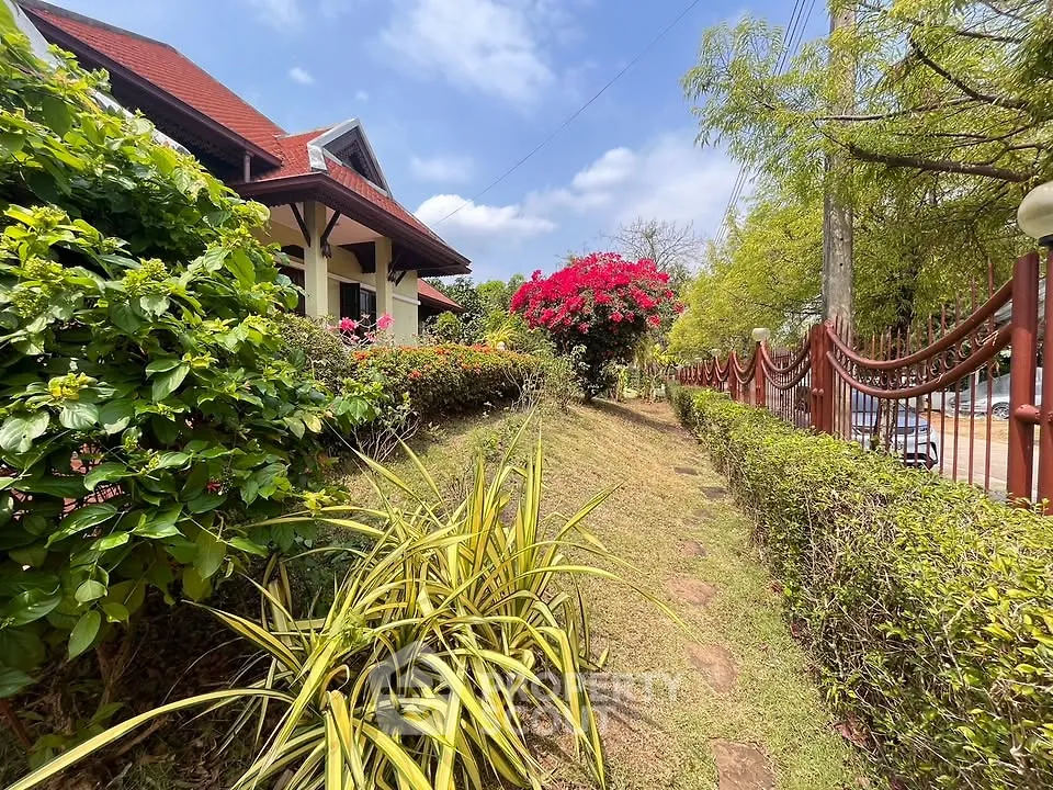 Charming garden path leading to a picturesque house with lush greenery and vibrant flowers.