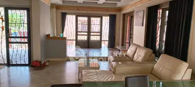 Spacious living room with elegant leather sofas and large windows for natural light.