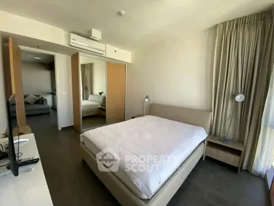 Spacious modern bedroom with mirrored closet and natural light