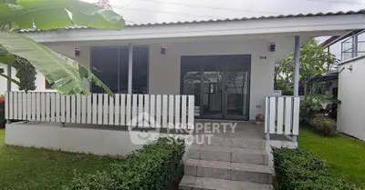 Charming single-story house with inviting front porch and lush greenery