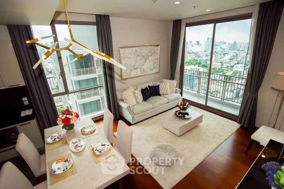 Luxurious living room with city view, elegant decor, and spacious balcony in modern high-rise apartment.