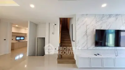 Modern interior with marble accent wall, sleek staircase, and mounted TV in a spacious living area.