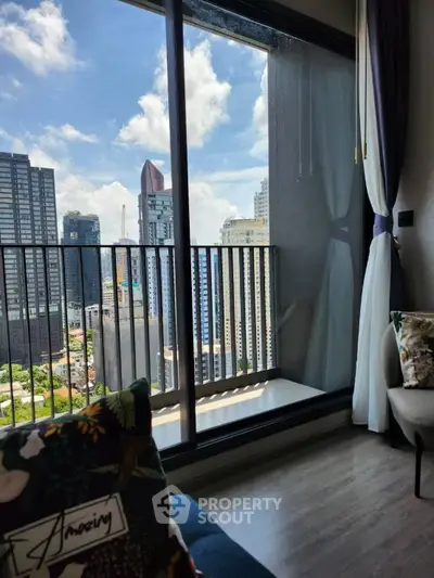 Stunning city view from modern apartment balcony with floor-to-ceiling windows.