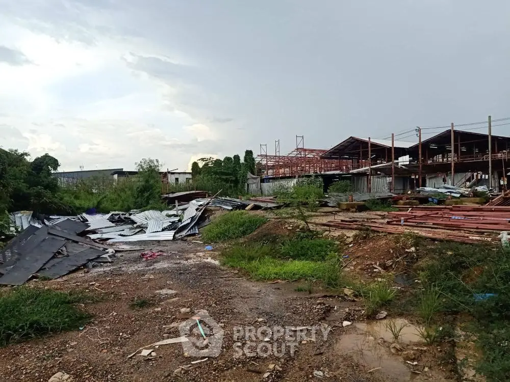 Vacant industrial land with construction materials and structures under development.