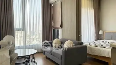 Modern studio apartment with large windows and stylish furnishings
