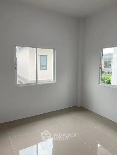 Bright empty room with tiled floor and large windows in modern home