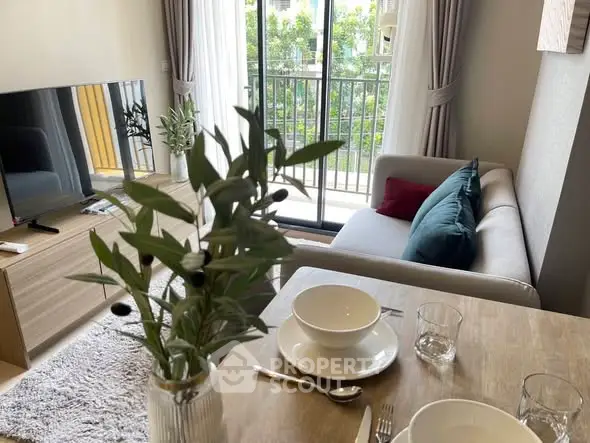 Modern living room with balcony view, stylish decor, and cozy seating area.