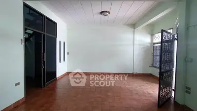 Spacious empty room with tiled floor and open door, ideal for customization.
