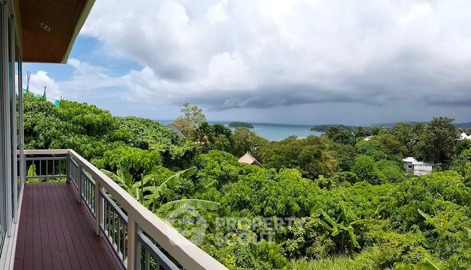 Stunning balcony view overlooking lush greenery and ocean horizon, perfect for serene living.