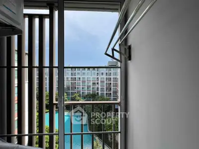 Stunning balcony view overlooking a pool and modern apartment complex.