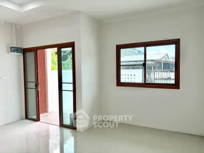 Bright and airy interior with large windows and sliding glass door leading to outdoor space.
