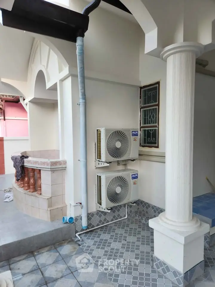 Elegant exterior with dual air conditioning units and stylish architectural columns.