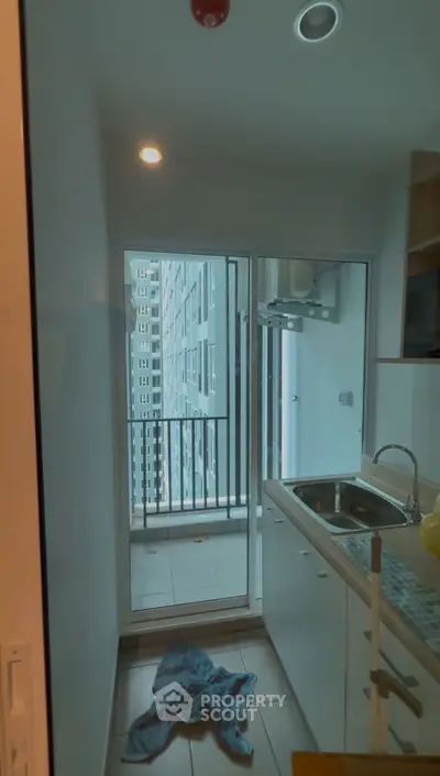 Compact kitchen with balcony view in modern apartment