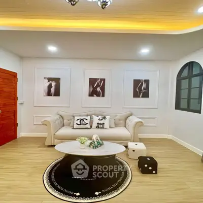 Elegant living room with plush sofa and modern decor, featuring stylish wall art and ambient lighting.