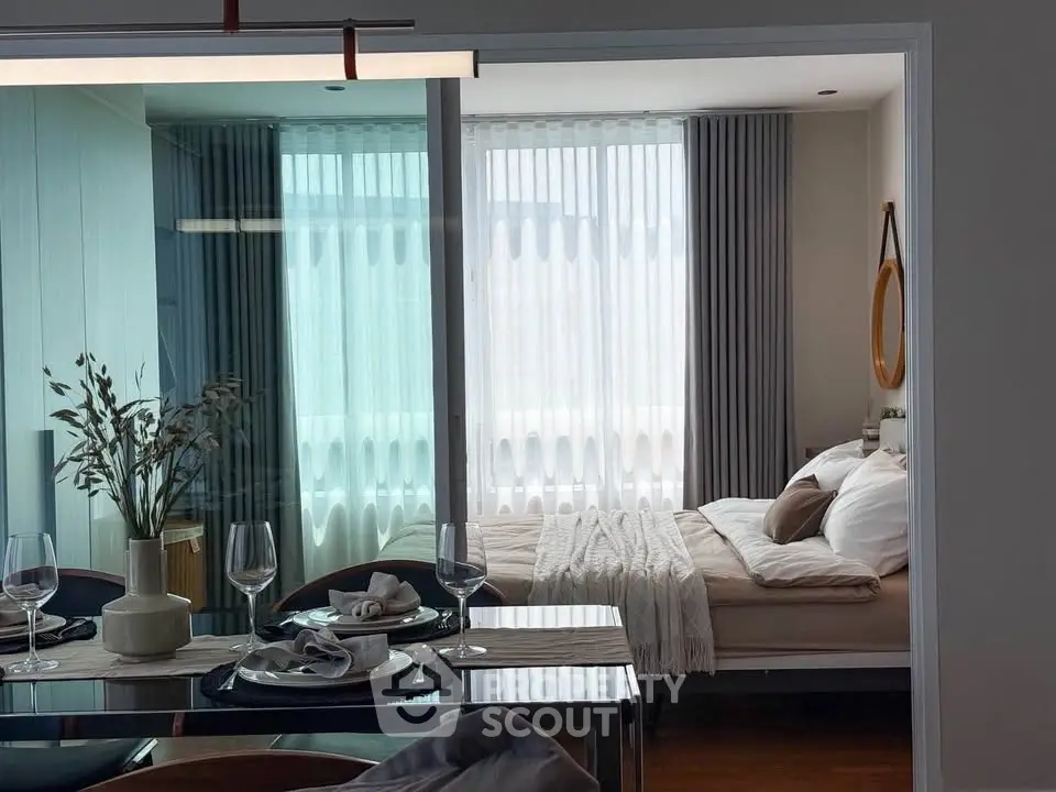 Modern studio apartment with elegant dining area and cozy bedroom, featuring stylish decor and natural light.