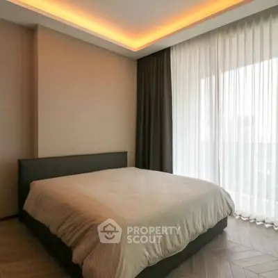 Modern bedroom with elegant lighting and large window in a stylish apartment.