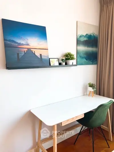Modern study area with white desk, green chair, and scenic wall art.