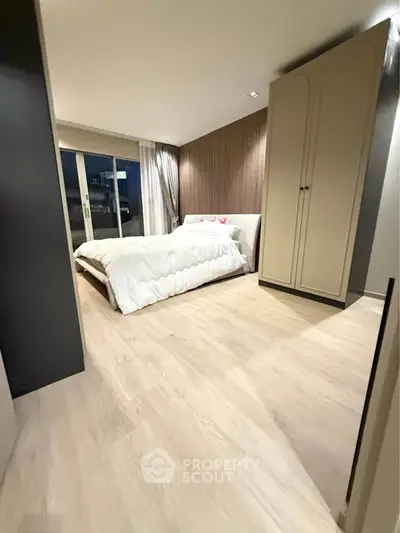 Spacious modern bedroom with elegant decor and large windows for natural light.