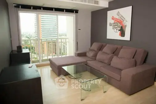 Modern living room with glass coffee table and city view balcony.