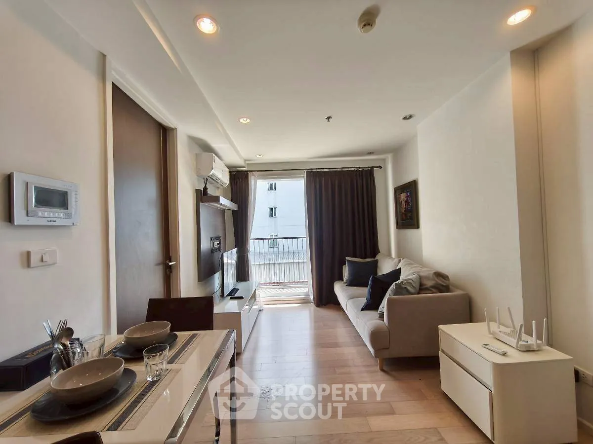 Modern living room with balcony, featuring sleek furniture and dining area, perfect for urban living.