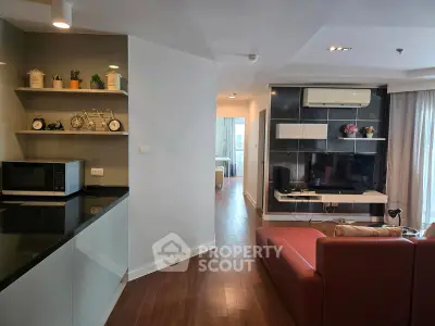 Modern living room with sleek kitchen, stylish decor, and cozy ambiance in a contemporary apartment.