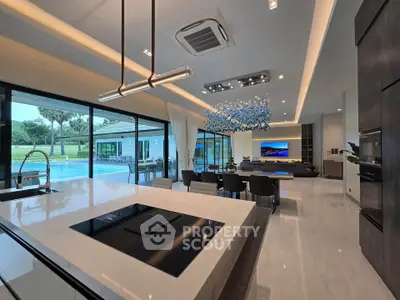 Luxurious open-plan living room with modern kitchen and pool view