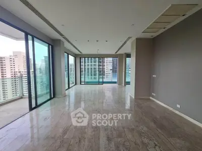 Spacious modern living room with panoramic city views and large balcony access.