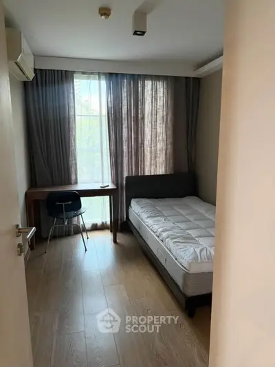Cozy bedroom with natural light, featuring a single bed and study desk, perfect for a serene living space.