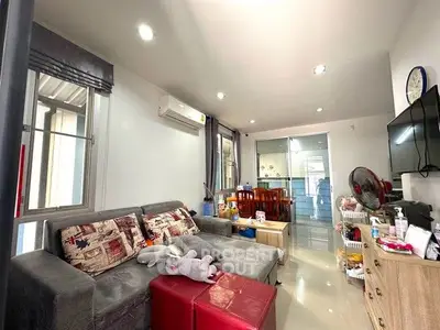 Modern living room with cozy sofa and dining area, featuring bright lighting and stylish decor.