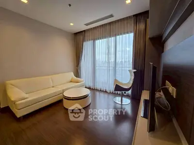 Modern living room with city view, featuring sleek furniture and floor-to-ceiling windows.