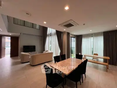 Spacious modern living and dining area with high ceilings and elegant furnishings.