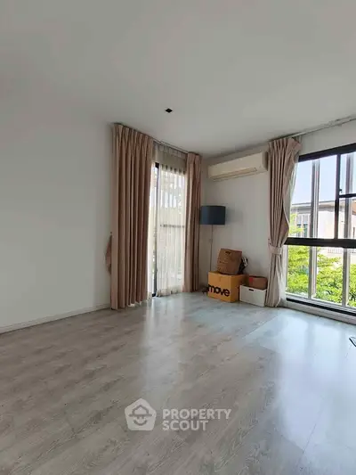 Spacious empty room with large windows and air conditioning, perfect for customization.