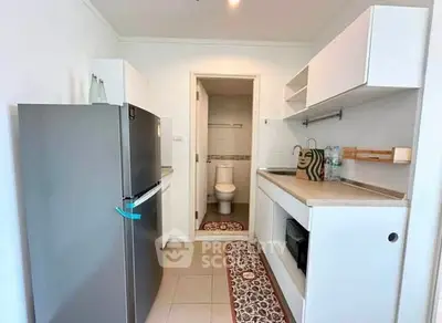 Modern kitchen with sleek appliances and open layout, featuring a stylish fridge and compact design.