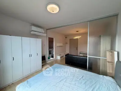 Spacious bedroom with modern sliding doors and ample storage in a stylish apartment.