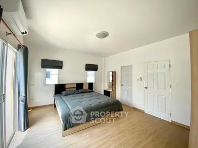 Spacious bedroom with modern decor and natural light in a stylish apartment.