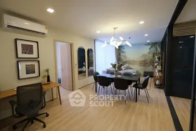 Modern living room with stylish dining area and workspace, featuring elegant lighting and contemporary decor.