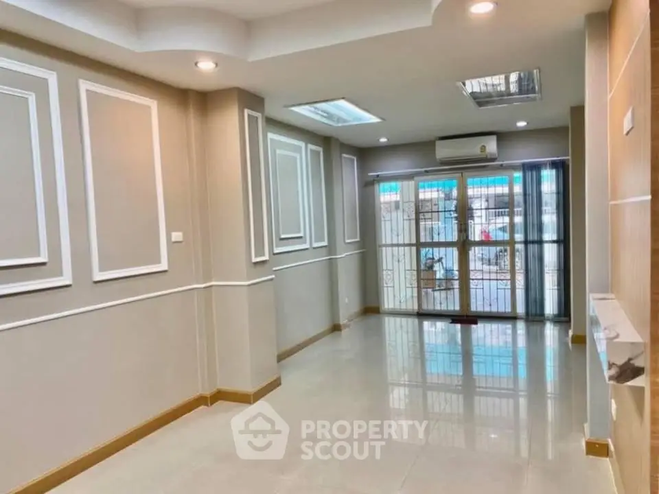 Spacious living room with elegant molding and large windows for natural light.
