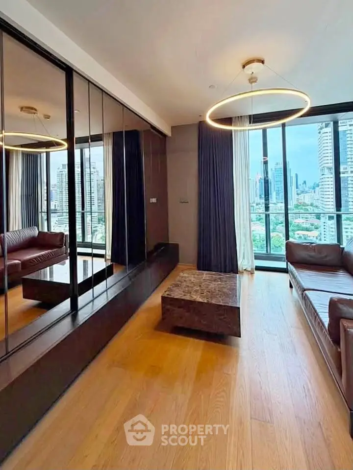 Luxurious living room with city view, modern lighting, and elegant wooden flooring.