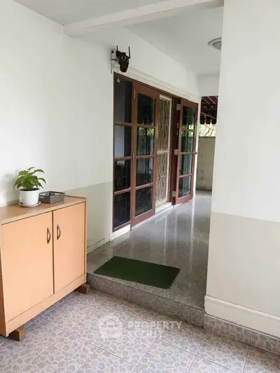 Charming entrance with elegant wooden doors and tiled flooring, perfect for a welcoming home ambiance.