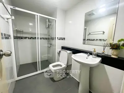 Modern bathroom with glass shower, sleek fixtures, and elegant decor